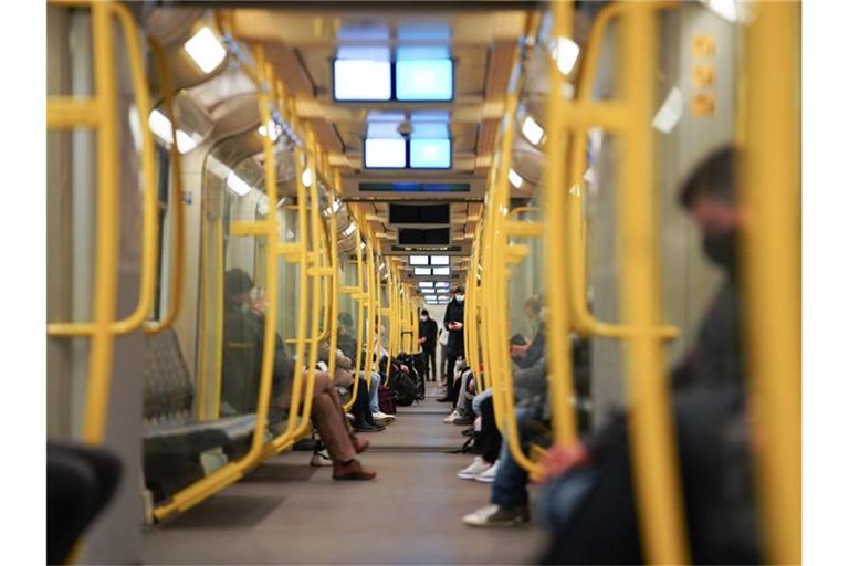 Nur wenige Fahrgäste sitzen in einer Bahn. Foto: Jörg Carstensen/dpa