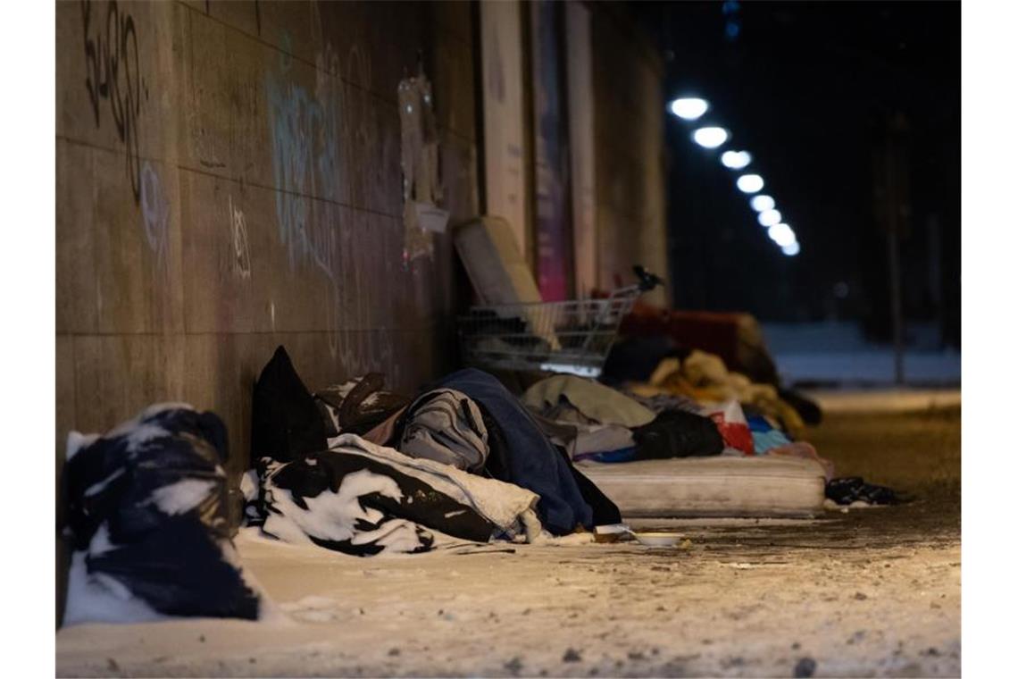 Obdachlose haben bei eisigen Temperaturen und Schnee unter einer Brücke am Bahnhof Zoo in Berlin ihr Lager errichtet und schlafen. Foto: Paul Zinken/dpa