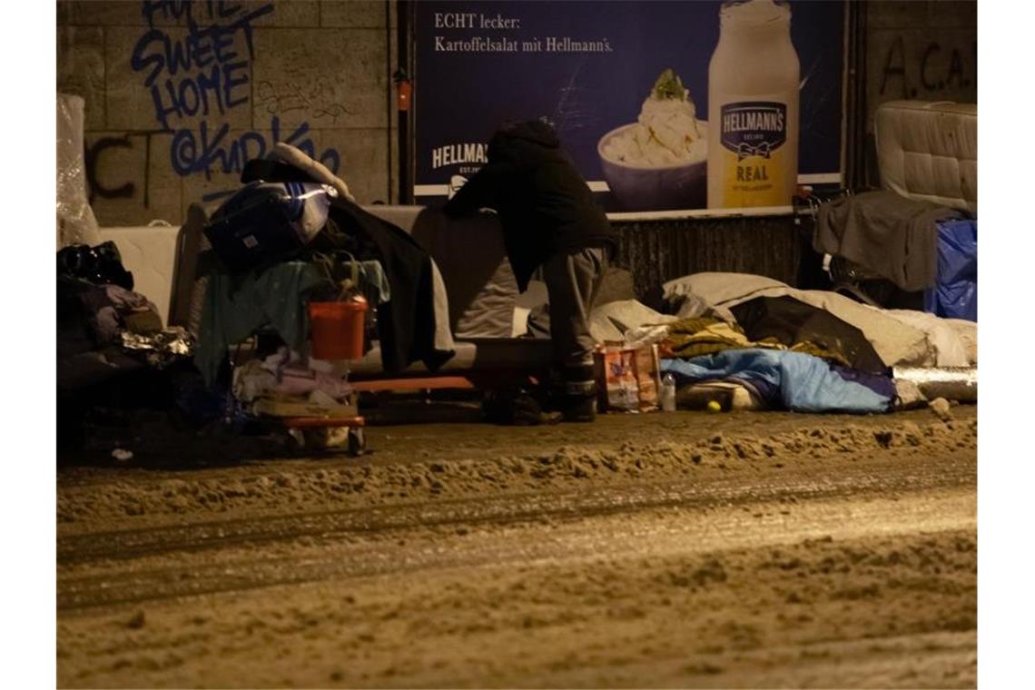 Obdachlose haben bei eisigen Temperaturen und Schnee unter einer Brücke am Bahnhof Zoo in Berlin ihr Lager errichtet. Foto: Paul Zinken/dpa