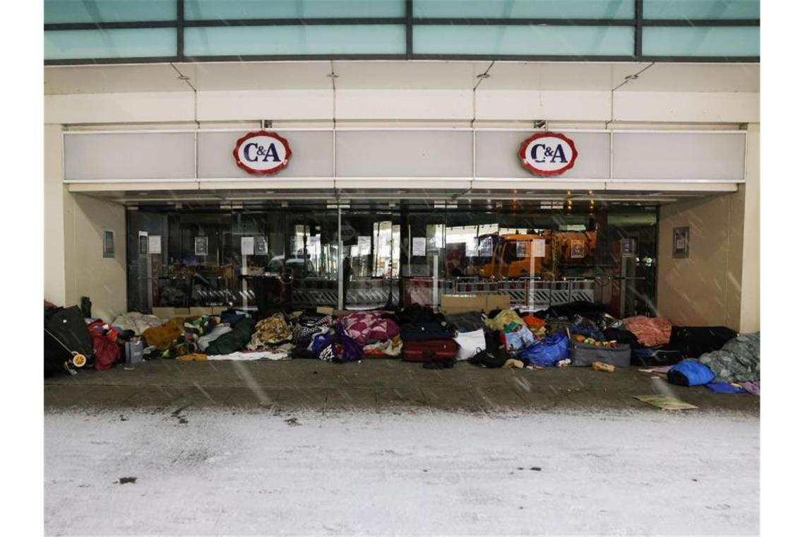Obdachlose Menschen haben ihren Schlafplatz im Eingang eines Kaufhauses in der Innenstadt aufgeschlagen. Foto: Christian Charisius/dpa