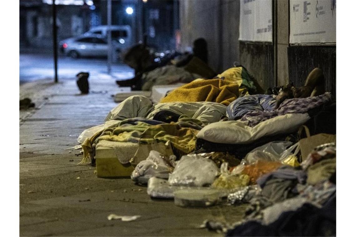 Obdachlose Menschen liegen unter einer Brücke am Berliner Zoo. Foto: Paul Zinken/dpa