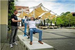 Oberbürgermeister Maximilian Friedrich lässt sich von Felix Mattl die Schulterpresse erklären. Sie ist eines von sieben neuen Fitnessgeräten am Willy-Brandt-Platz. Foto: Alexander Becher