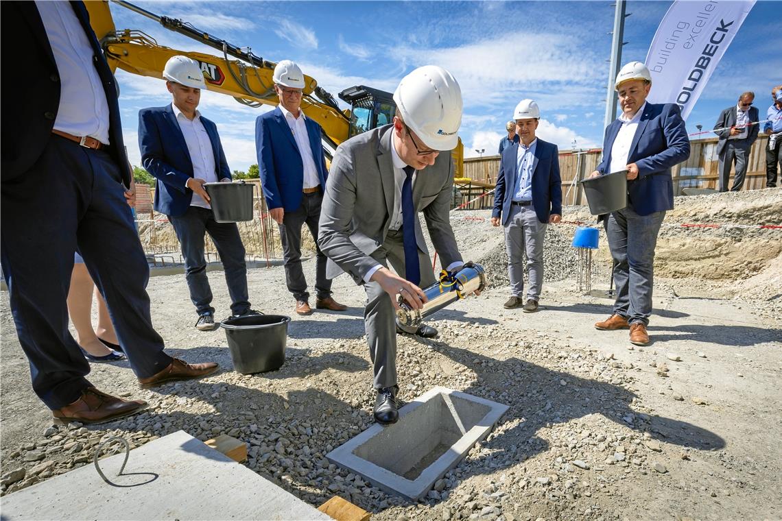 Grundsteinlegung für die neue Backnanger Sporthalle Oberbürgermeister Maximilian Friedrich legt eine Zeitkapsel mit zeitgeschichtlichen Dokumenten in den Grundstein, der anschließend von Timm Ruckaberle, Rainer Mögle, Hasan Garic und Stefan Setzer (von links) zugemauert wird.Foto: Alexander Becher