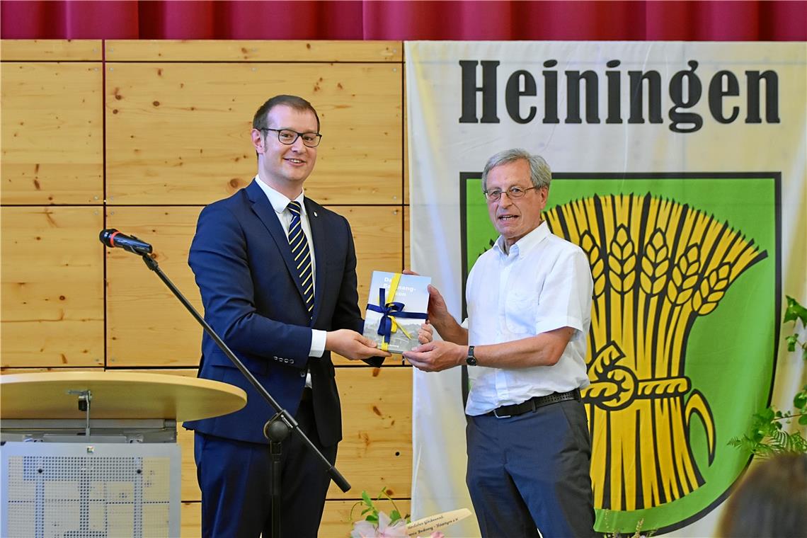 Oberbürgermeister Maximilian Friedrich (links) überreicht Ortsvorsteher Leonhard Groß das Backnang-Lexikon. Foto: Tobias Sellmaier
