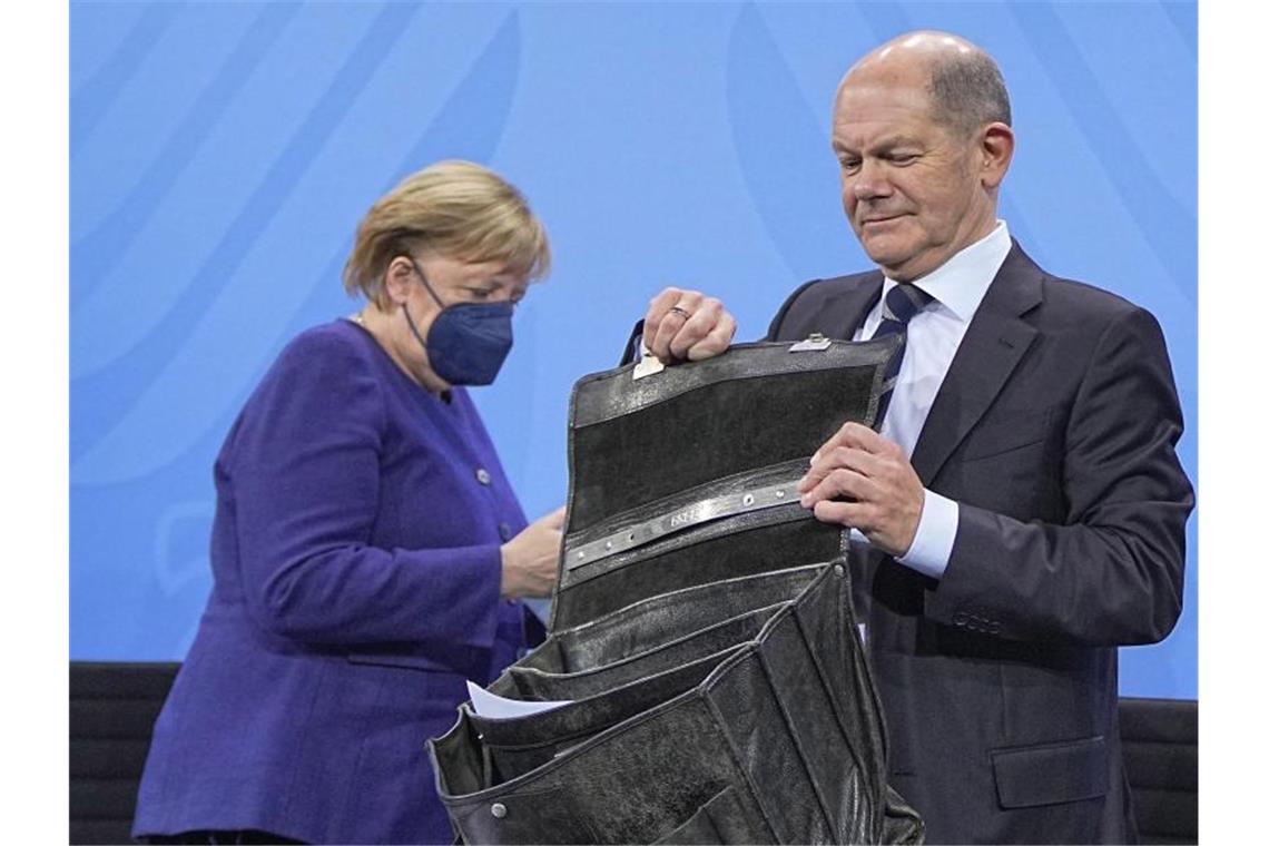 Vom neuen Stil in der deutschen Politik Olaf Scholz mit alter Aktentasche, links die geschäftsführende Kanzlerin Angela Merkel. Foto: Michael Kappeler/dpa POOL/dpa
