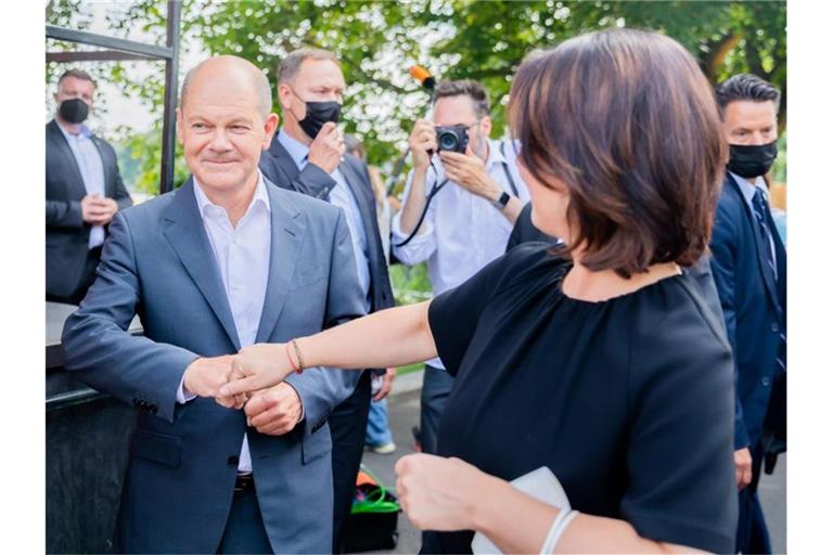 Olaf Scholz (SPD, 2.v.l.), Bundesfinanzminister und SPD-Kanzlerkandidat, und Annalena Baerbock, Kanzlerkandidatin und Bundesvorsitzende von Bündnis 90/Die Grünen, begrüßen sich zu Beginn einer Wahlkampf-Veranstaltung. Foto: Christoph Soeder/dpa