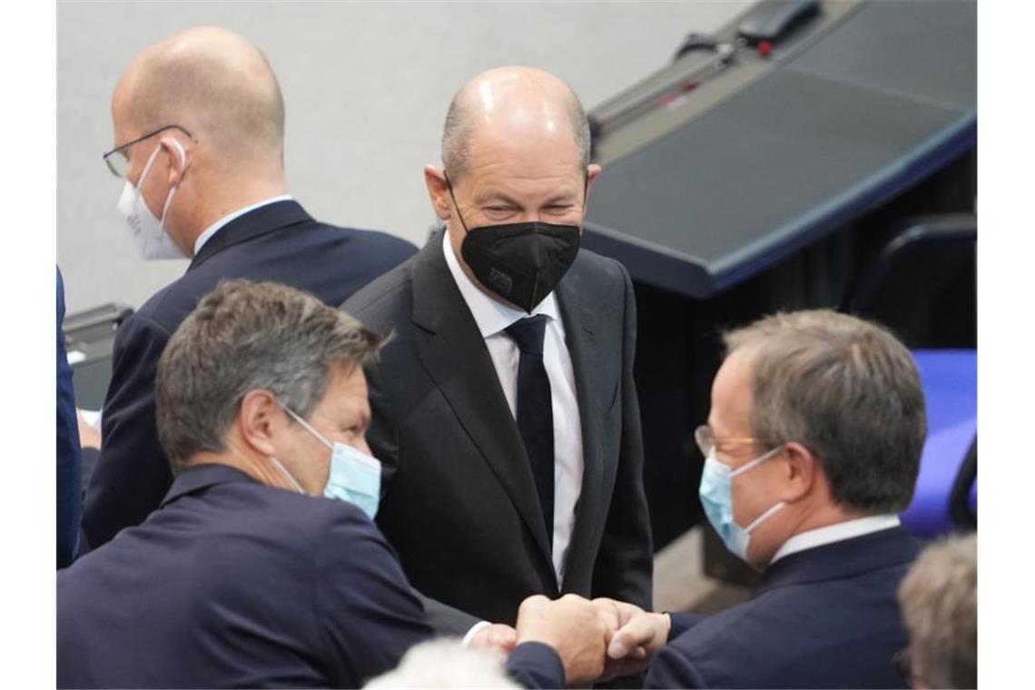 Corona-Krisenrunde von Bund und Ländern nächste Woche Olaf Scholz, SPD-Kanzlerkandidat und Bundesminister der Finanzen, steht zu Beginn der Sitzung des Bundestags mit Robert Habeck (l), Bundesvorsitzender von Bündnis 90/Die Grünen, und Armin Laschet (r), CDU-Bundesvorsitzender, zusammen. Foto: Kay Nietfeld/dpa