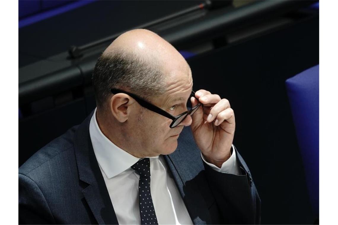 Volkswirte sehen Aufschwung in Gefahr Olaf Scholz verfolgt eine Debatte im Bundestag. Foto: Michael Kappeler/dpa