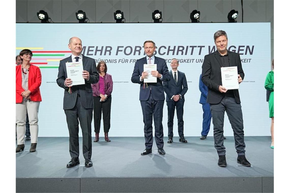 Olaf Scholz (vorne v. l.), Christian Lindner und Robert Habeck präsentieren den frisch unterschriebenen Koalitionsvertrag von SPD, Grünen und FDP. Foto: Michael Kappeler/dpa