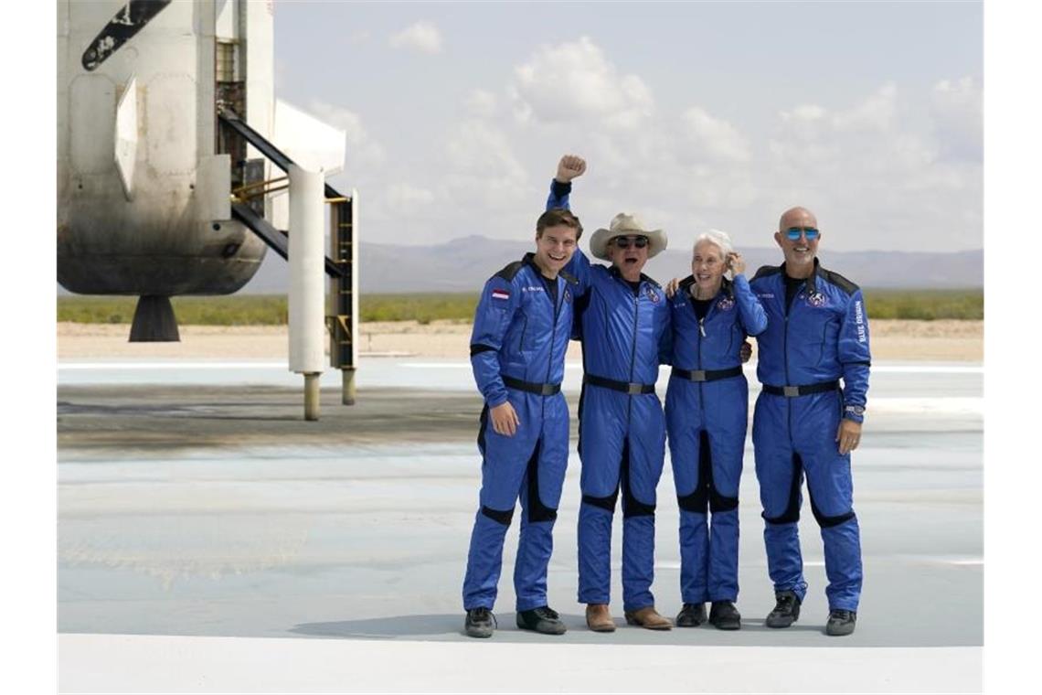 Oliver Daemen (l-r) aus den Niederlanden, Jeff Bezos, Gründer von Amazon und des Weltraumtourismus-Unternehmens Blue Origin, Wally Funk, ehemalige US-Pilotin, und Mark Bezos, Bruder von Jeff Bezos, stehen nach der Landung für ein Foto zusammen. Foto: Tony Gutierrez/AP/dpa