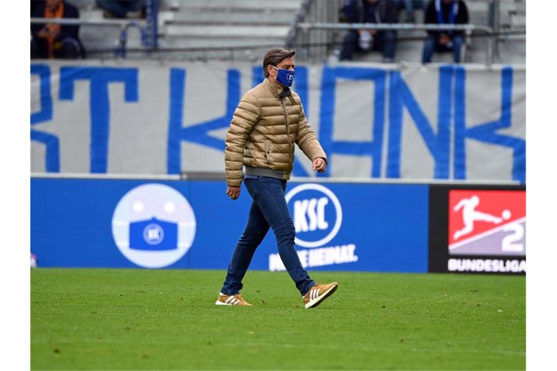 Oliver Kreuzer, Sportdirektor vom Karlsruher SC, geht über das Spielfeld. Foto: Uli Deck/dpa/Archivbild