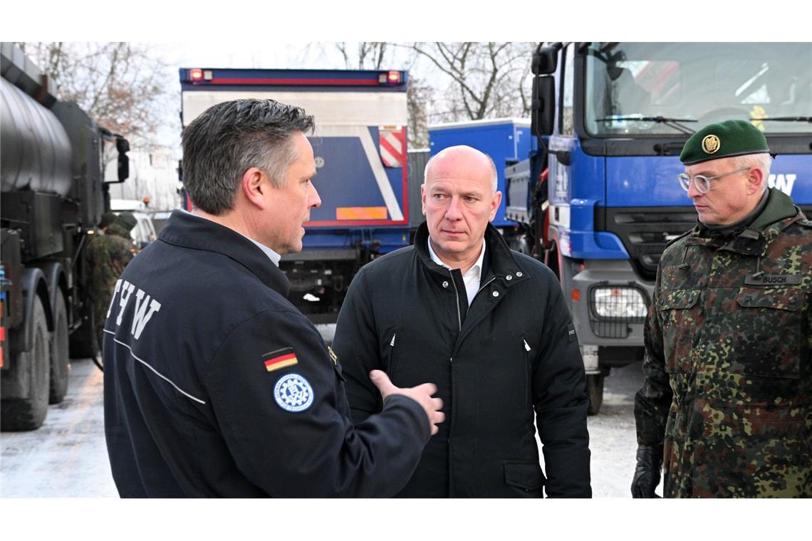 Oliver Schultz (l-r) vom Technischen Hilfswerk, Kai Wegner (CDU), Regierender Bürgermeister, und Brigadegeneral Horst Busch, unterhalten sich.