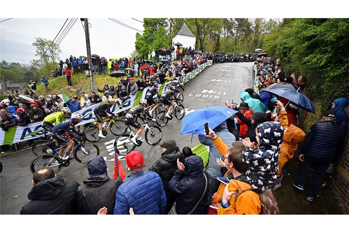 Sieg an der Mauer von Huy: Pogacar gewinnt Flèche Wallonne Olympiasieger Remco Evenepoel (M) mit goldenem Helm an der Mauer von Huy. Rechts neben ihm Tadej Pogacar.