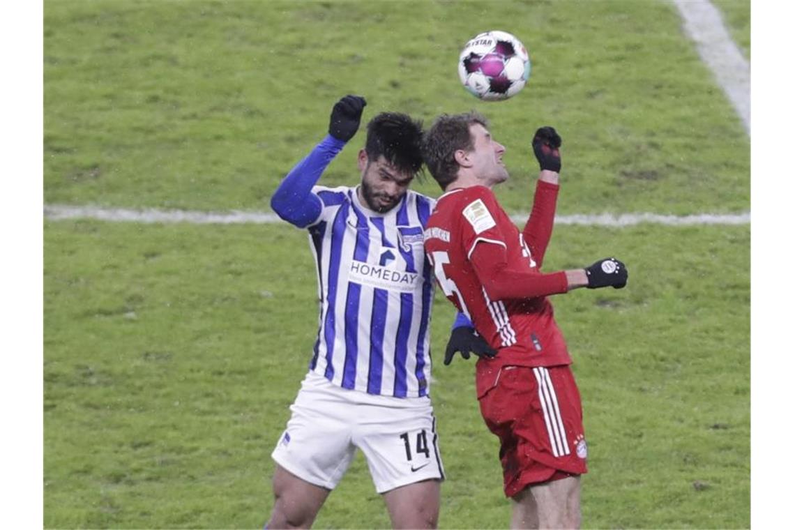 Bayern nach Chaos-Reise in Katar gelandet Omar Alderete von Hertha BSC ist gegen Thomas Müller von Bayern München in Aktion. Foto: Michael Sohn/AP-Pool/dpa