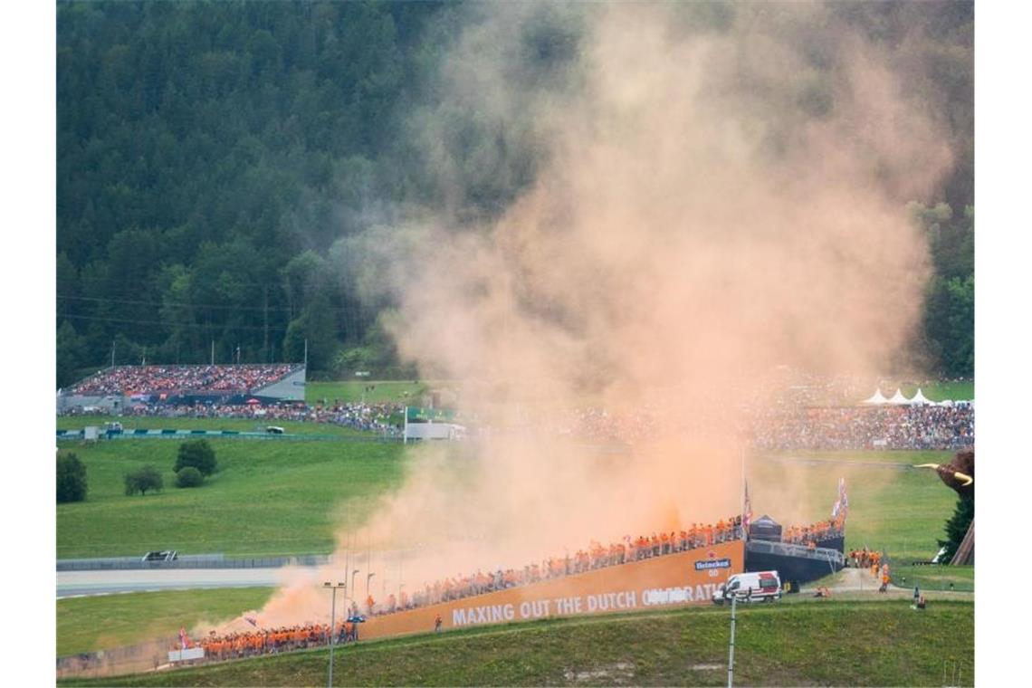 Oranje-Party in Spielberg: Verstappen voll auf Titelkurs Oranger Bengalo-Rauch lag das ganze Wochenende über der Strecke. Foto: Georg Hochmuth/APA/dpa