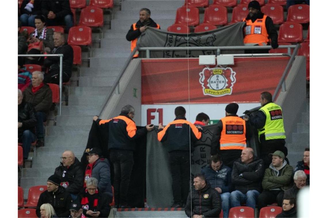 Bedrückende Stille: „Man merkt, wie unwichtig Fußball ist“ Ordner halten Decken hoch, um einen Notarzteinsatz abzuschirmen. Foto: Federico Gambarini/dpa