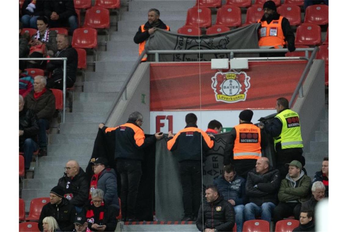 Ordner halten Decken hoch, um einen Notarzteinsatz abzuschirmen. Foto: Federico Gambarini/dpa