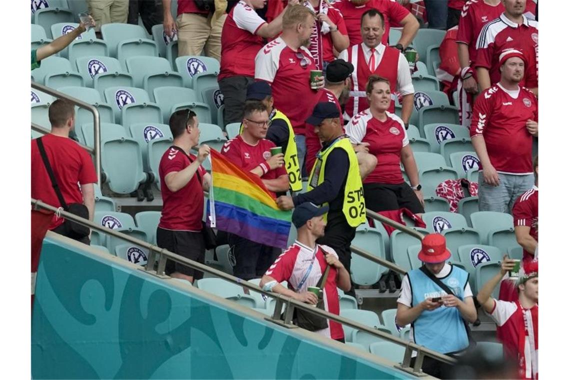 Regenbogenfahne in Baku - UEFA irritiert mit Stellungnahme Ordner nehmen zwei Dänemark Fans eine Regenbogen-Fahne ab. Foto: Darko Vojinovic/Pool AP/dpa