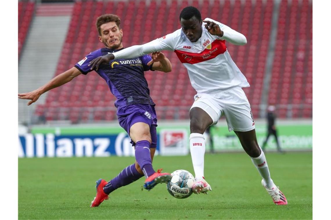 Osnabrücks Bashkim Ajdini (l) gegen Tanguy Coulibaly von Stuttgart. Foto: Tom Weller/dpa-Pool/dpa