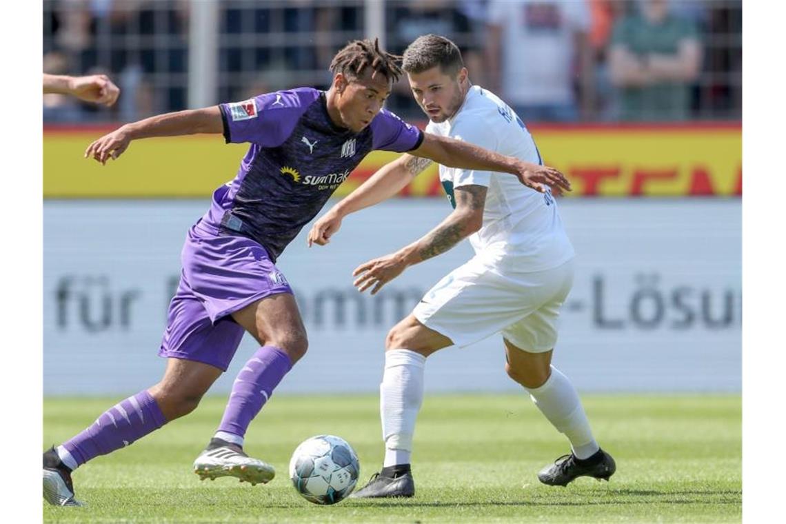 Osnabrücks Etienne Amenyido und Marnon Busch aus Heidenheim (l-r.) im Zweikampf um den Ball. Foto: Friso Gentsch