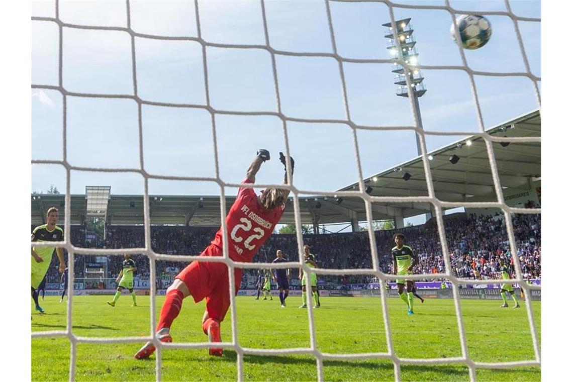 Osnabrücks Keeper Philipp Kühn (M) kann das Gegentor gegen Aue nicht verhindern. Foto: Robert Michael