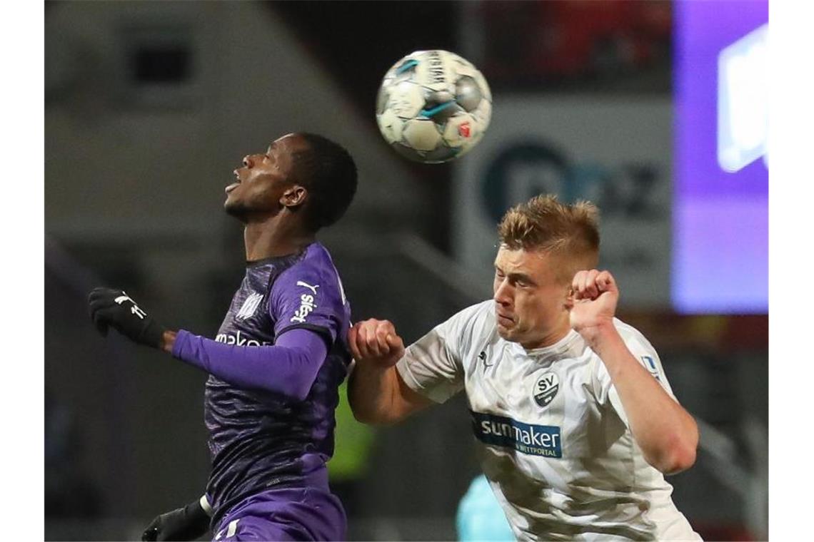 Osnabrücks Neuzugang Assan Ceesay (l) im Kampf um den Ball mit Aleksandr Zhirov aus Sandhausen. Foto: Friso Gentsch/dpa