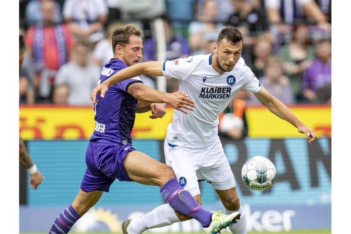 Osnabrücks Ulrich Taffertshofer (l) und Karlsruhes Lukas Fröde kämpfen um den Ball. Foto: David Inderlied