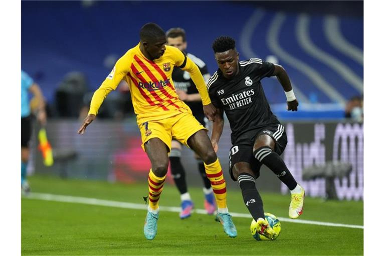 Ousmane Dembélé (l) vom FC Barcelona im Duell mit Real-Profi Vinicius Junior. Foto: Manu Fernandez/AP/dpa