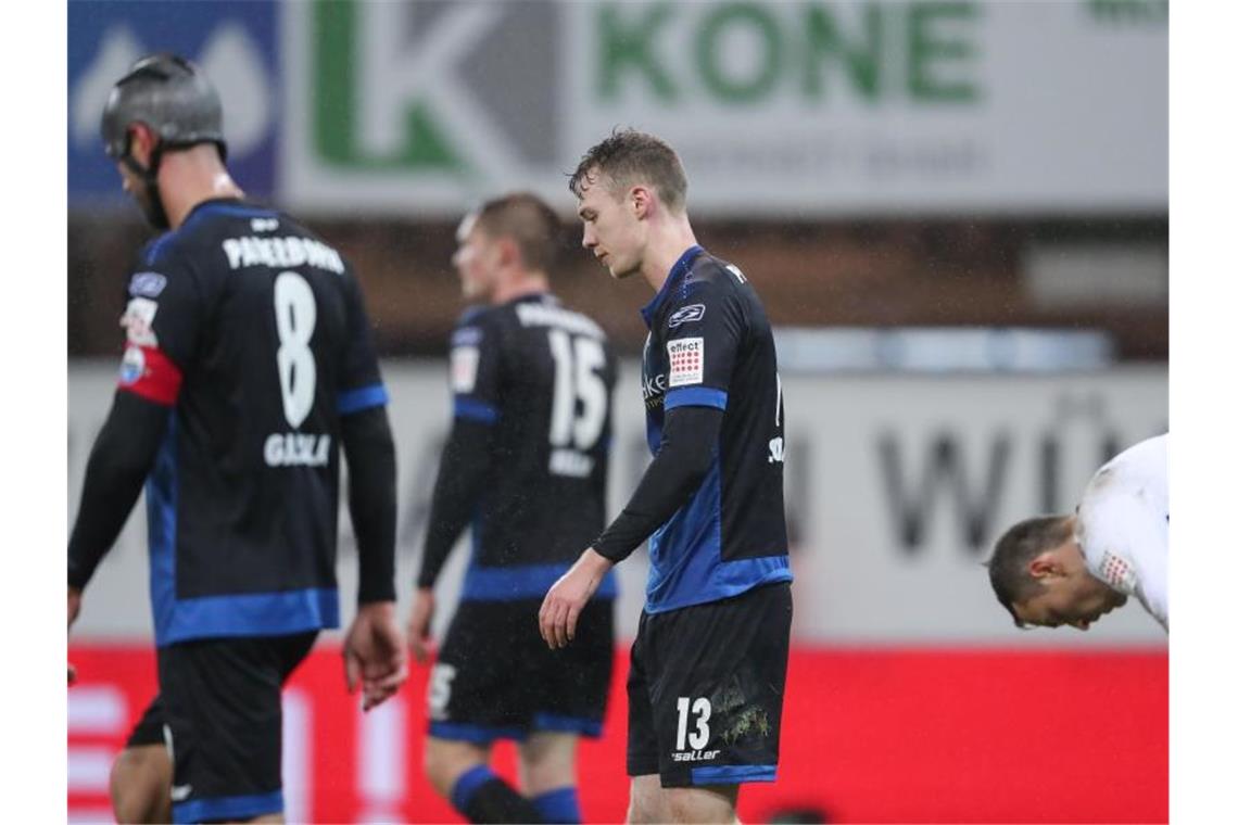 Paderborns Hintermannschaft um Sebastian Schonlau (M) lässt nach dem Gegentreffer zum 0:3 die Köpfe hängen. Foto: Friso Gentsch/dpa