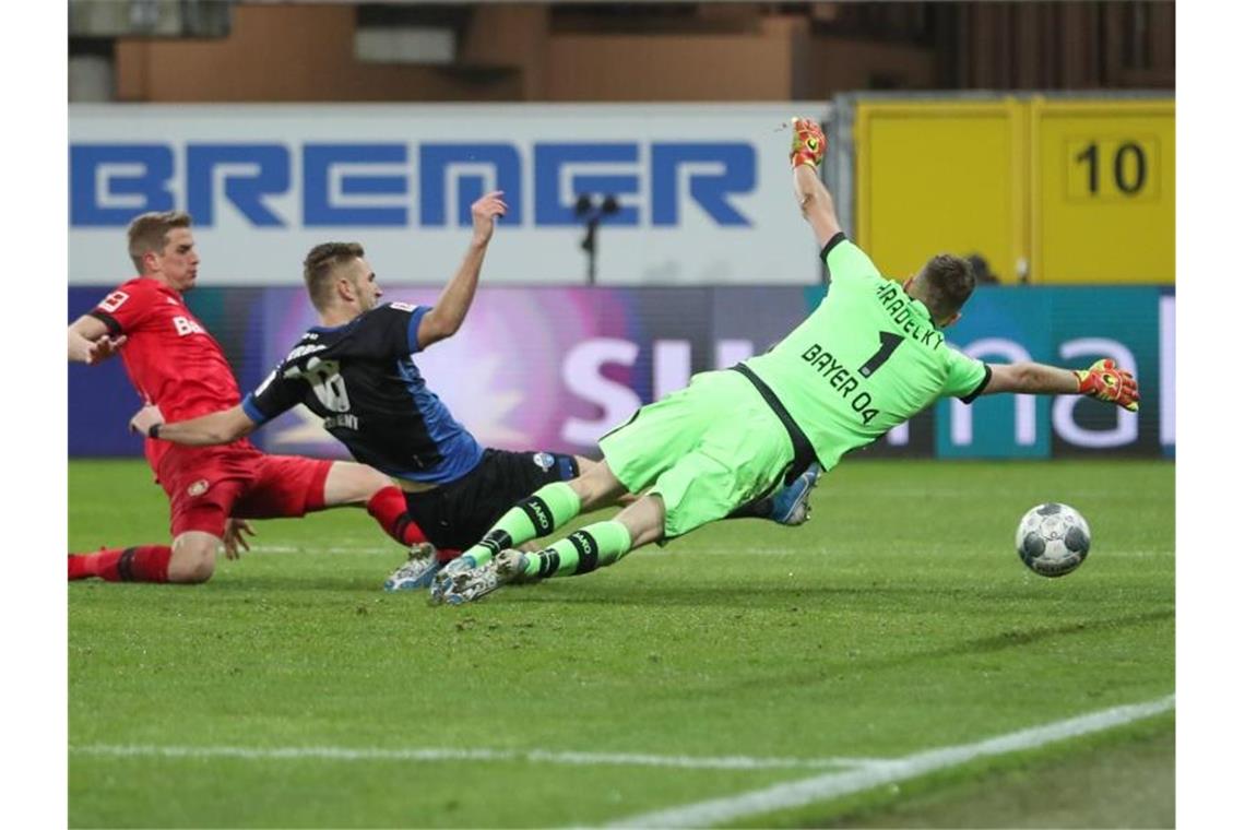 Paderborns Srbeny (M) erzielt den Treffer zum zwischenzeitlichen 1:3 - Bayers Schlussmann Hradecky streckt sich vergebens. Foto: Friso Gentsch/dpa