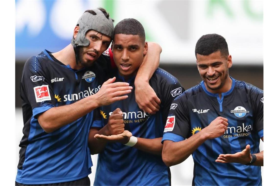 Revierderby torlos, Bayern an der Spitze, Leipzig enttäuscht Paderborns Torschütze Abdelhamid Sabiri (M) feiert seinen Treffer zum 1:0 mit Klaus Gjasula (l) und Mohamed Dräger. Foto: Friso Gentsch/dpa