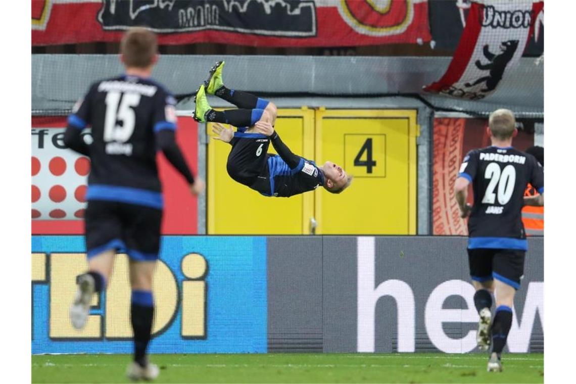 Paderborns Torschütze Kai Pröger (M) feiert seinen Treffer zum 1:1 mit einem Salto. Foto: Friso Gentsch/dpa