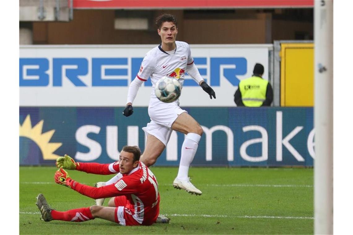 Paderborns Torwart Leopold Zingerle (l) kassiert den Trefer zum 0:1 durch Patrik Schick (r): Leipzig siegt mit 3:2 beim SC. Foto: Friso Gentsch/dpa