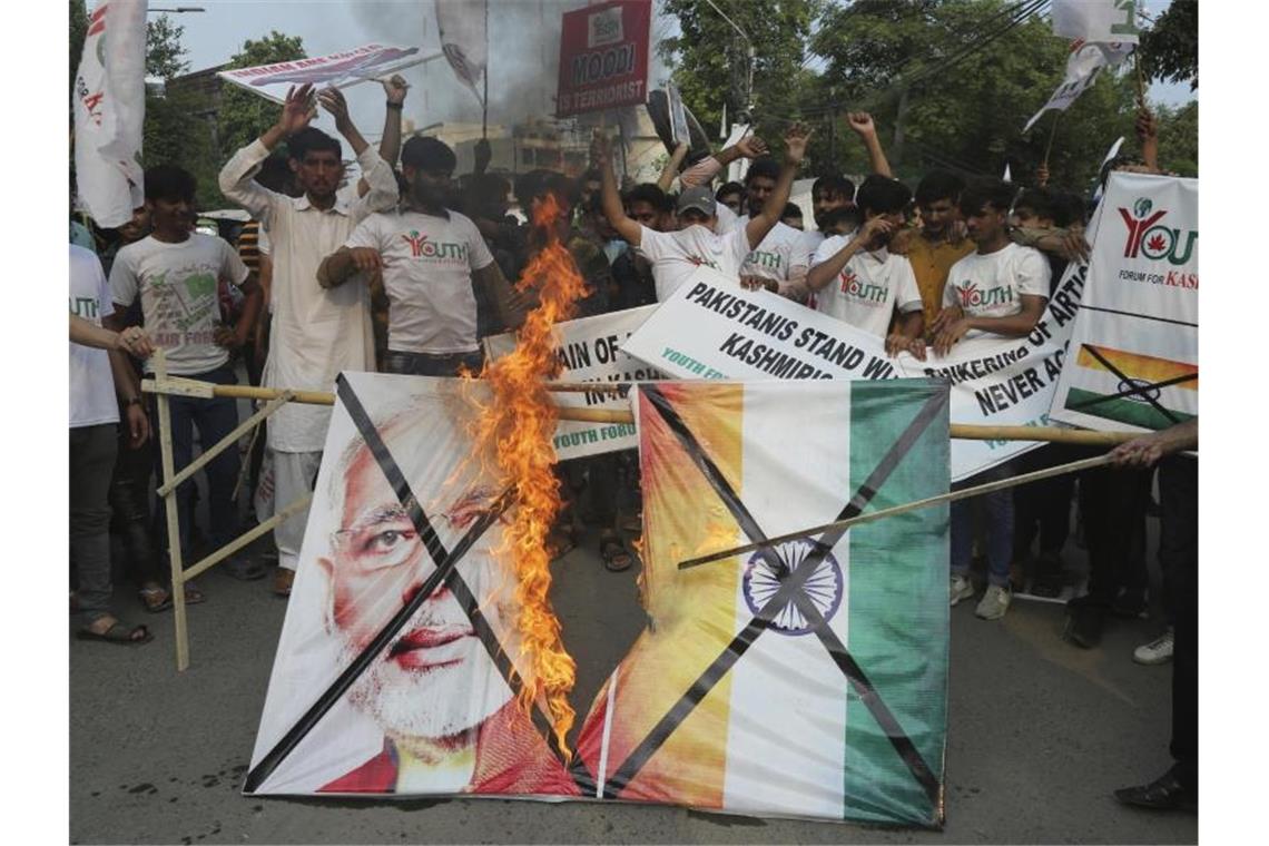 Pakistanische Demonstranten verbrennen bei einer Kundgebung in Lahore eine Fahne mit dem Bild des indischen Premierministers Modi. Foto: K.M. Chaudary/AP