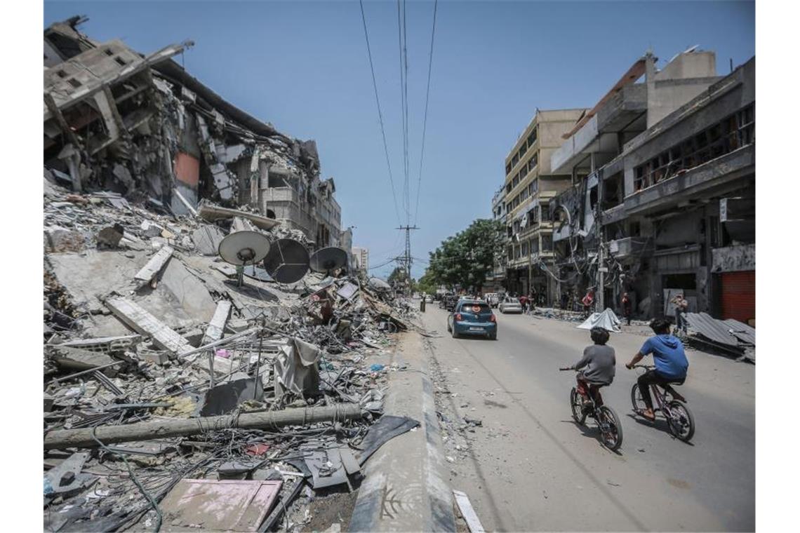 Waffenruhe in Nahost - Rufe nach umfassender Lösung Palästinenser fahren an Gebäuden in Gaza vorbei, die durch israelische Luftangriffe zerstört wurden. Foto: Mohammed Talatene/dpa