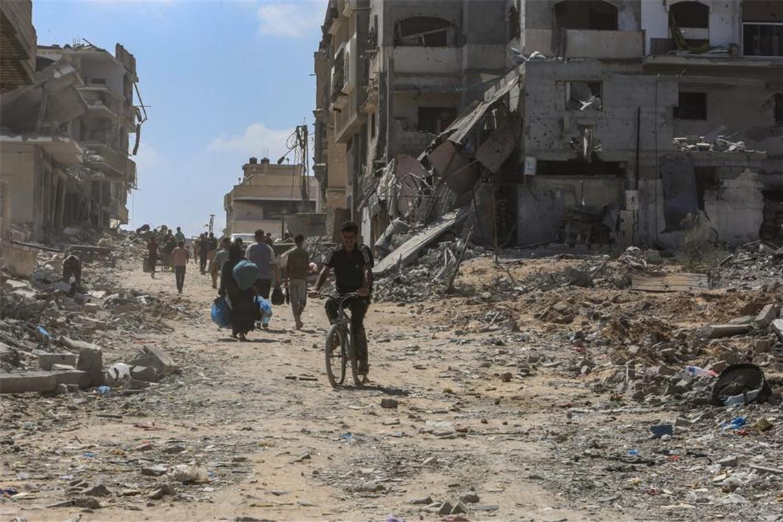 Netanjahu warnt Einwohner der Stadt Gaza: „verschwinden Sie" Palästinenser gehen im Sommer 2024 vor zerstörten Gebäuden entlang. (Archivbild)