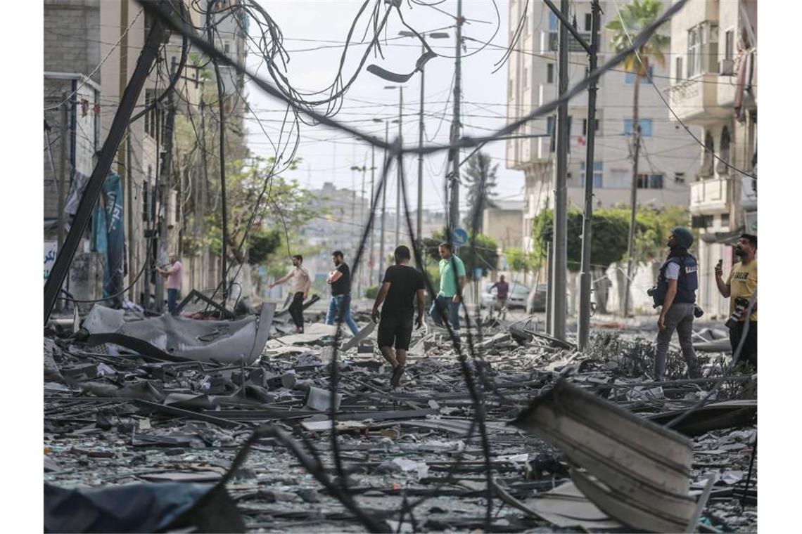 Keine Entspannung in Sicht - neue Angriffswelle in Israel Palästinenser inspizieren das Umfeld des schwer beschädigten Al-Jawhara-Turm, nachdem der Turm von israelischen Luftangriffen getroffen worden war. Foto: Mohammed Talatene/dpa
