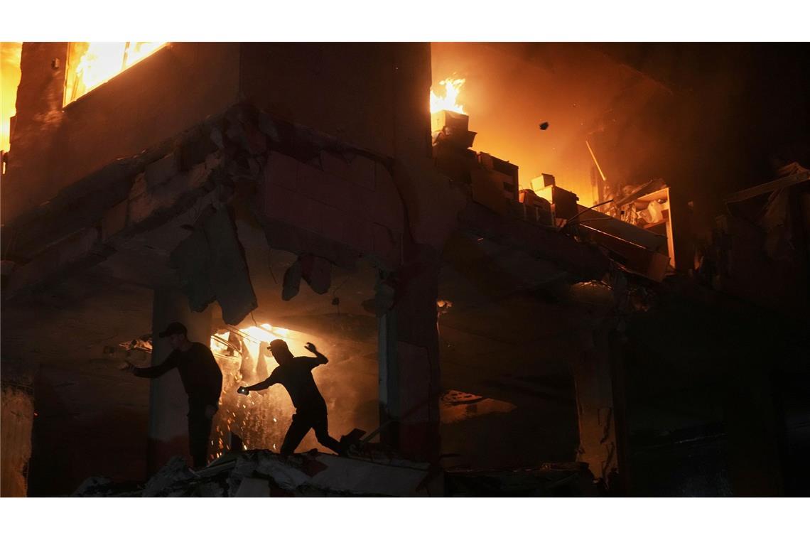 Palästinenser reagieren auf ein Feuer nach einem israelischen Angriff auf ein Wohnhaus im Stadtteil Rimal in Gaza Stadt.