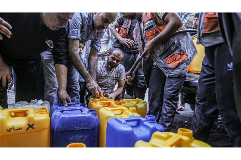 Palästinenser stehen Schlange, um Wasser zu bekommen.