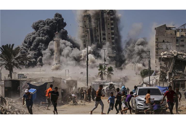 Palästinenser suchen während eines israelischen Luftangriffs auf ein Hochhaus im Gaza Schutz.