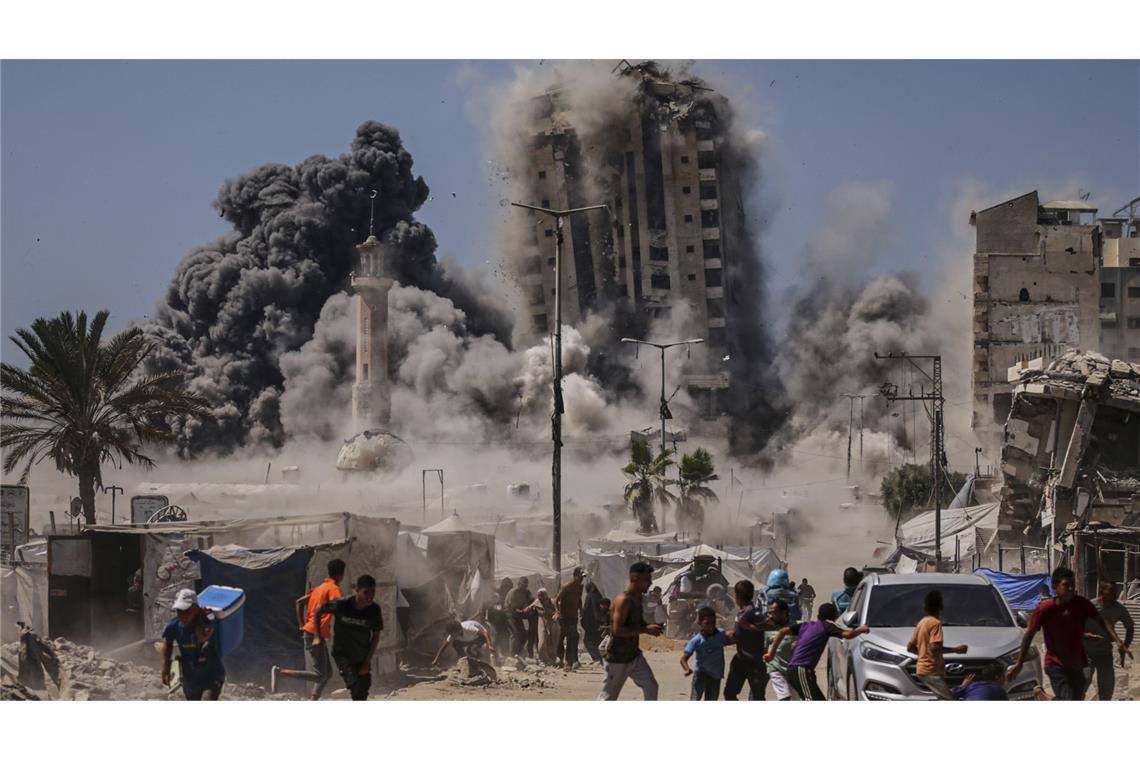 Bericht: 40 Tote bei Angriffen Israels in Gaza Palästinenser suchen während eines israelischen Luftangriffs auf ein Hochhaus im Gaza Schutz (Archivfoto).