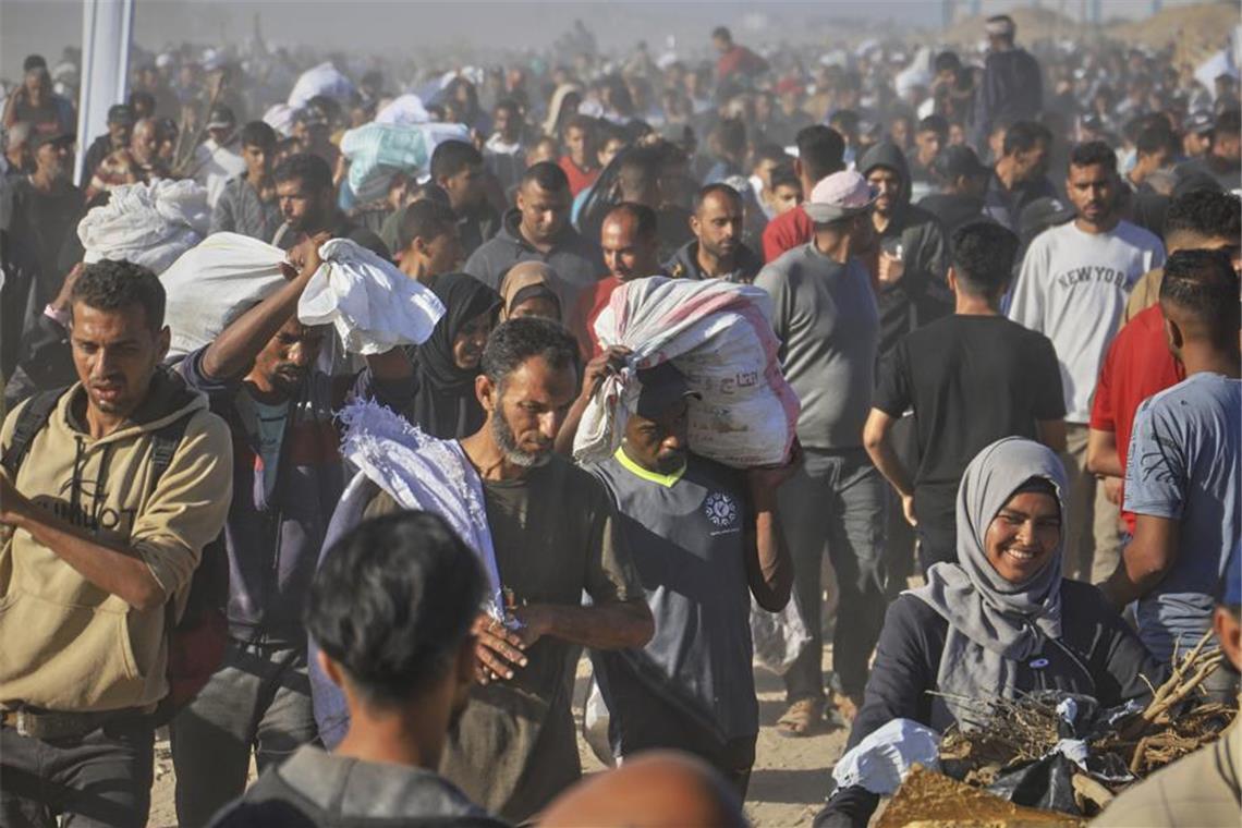 Palästinenser tragen in Rafah Kisten und Taschen mit Lebensmitteln und humanitären Hilfspaketen, die von der Gaza Humanitarian Foundation, einer von Israel anerkannten und von den USA unterstützten Organisation, geliefert wurden. (Archivbild)