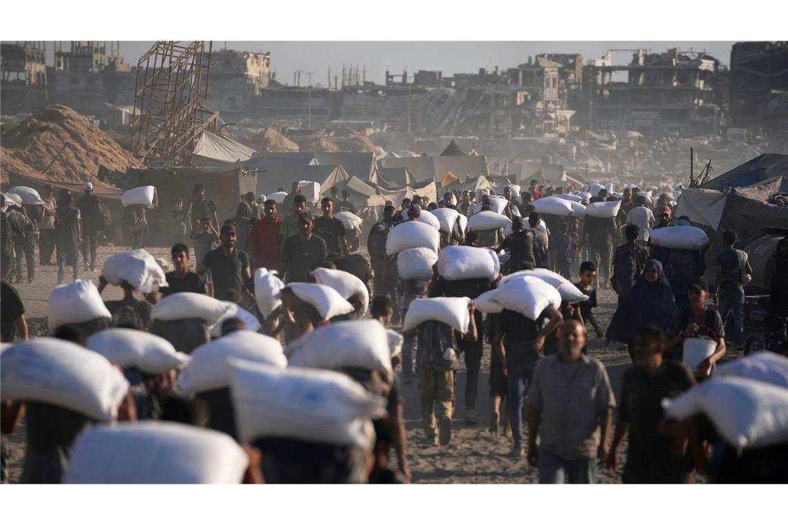Bilder des Tages Palästinenser tragen Mehlsäcke, die von einem humanitären Hilfskonvoi auf dem Weg vom nördlichen Gazastreifen nach Gaza abgeladen wurden.