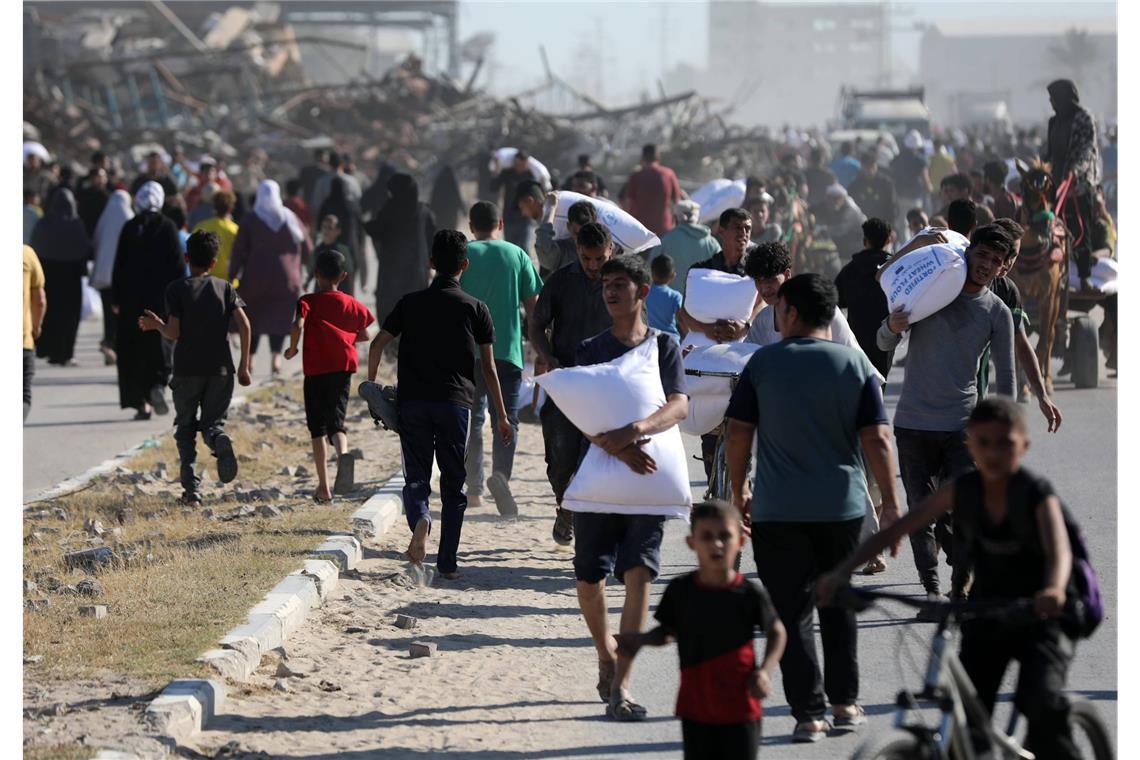 Netanjahu warnt Einwohner der Stadt Gaza: „verschwinden Sie" Palästinenser tragen Säcke mit Hilfsgütern (Archivbild).