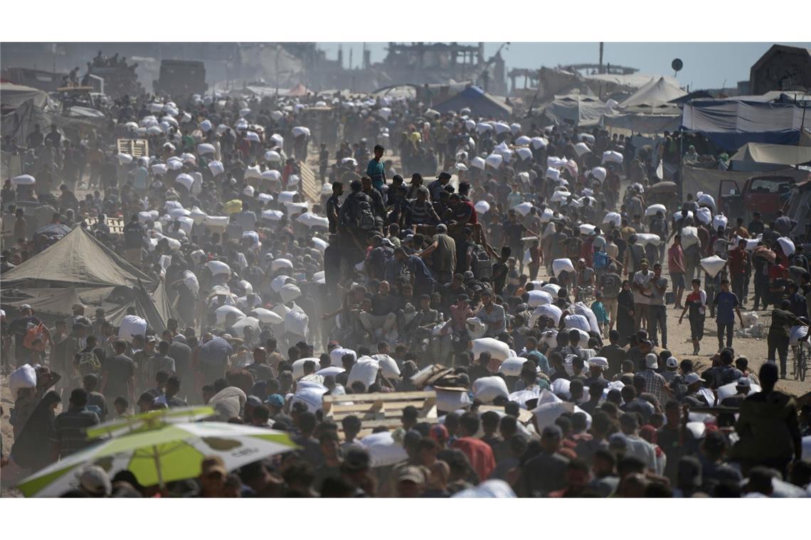 Hilfsgüter für Gaza: Warum sie oft nicht ankommen Palästinenser tragen Säcke mit Mehl aus einem Hilfskonvoi. (Archivbild)