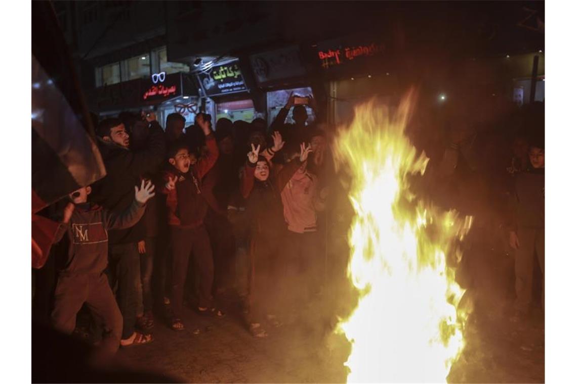 Palästinensische Kinder versammeln sich um brennende Reifen bei einem Protest im Flüchtlingslager Jabalia im nördlichen Gazastreifen gegen den Nahost-Plan von US-Präsident Trump. Foto: Mohammed Talatene/dpa