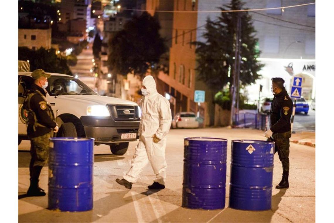 Mehr als 1000 Corona-Infektionen in Deutschland Palästinensische Sicherheitskräfte stehen vor dem Angel Hotel, das wegen eines Covid-19-Falls unter Quarantäne steht. Foto: Luay Sababa/XinHua/dpa