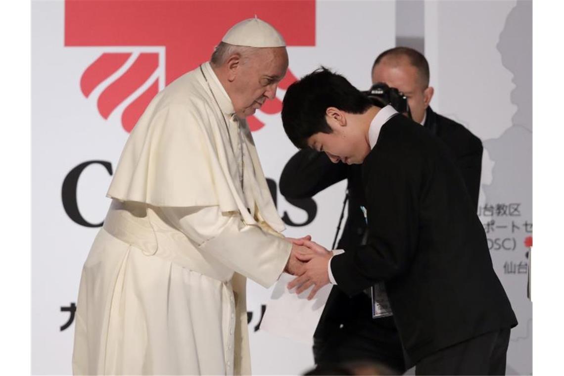Papst stellt Nutzung von Atomenergie in Frage Papst Franziskus begrüßt ein Fukushima-Opfer in Tokio. Foto: Jae Hong/AP/dpa