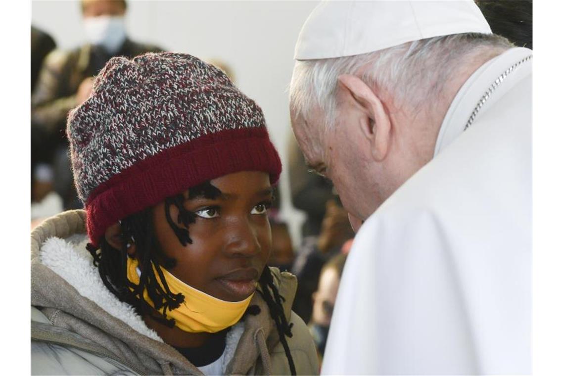 Papst Franziskus spricht während seines Besuchs im Migrantenlager Camp Kara Tepe mit einem Mädchen. Foto: Vatican Media/ANSA via ZUMA Press/dpa