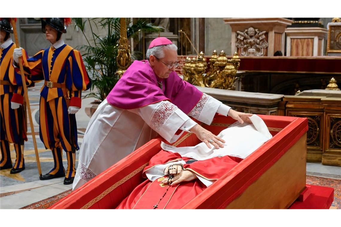 Papst Franziskus wird ein Leinentuch über das Gesicht gelegt.